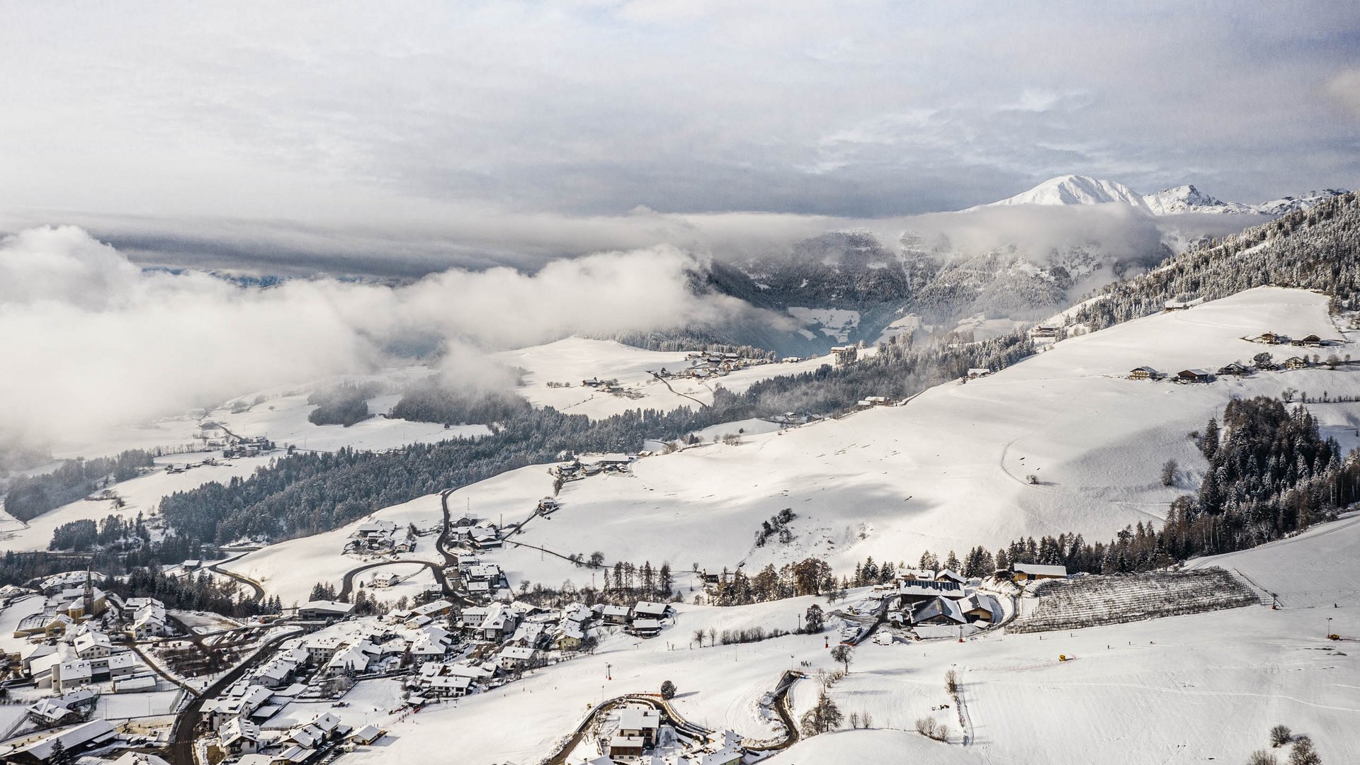 Terento in Val Pusteria Villaggio di montagna innevato con nuvole e montagne sullo sfondo