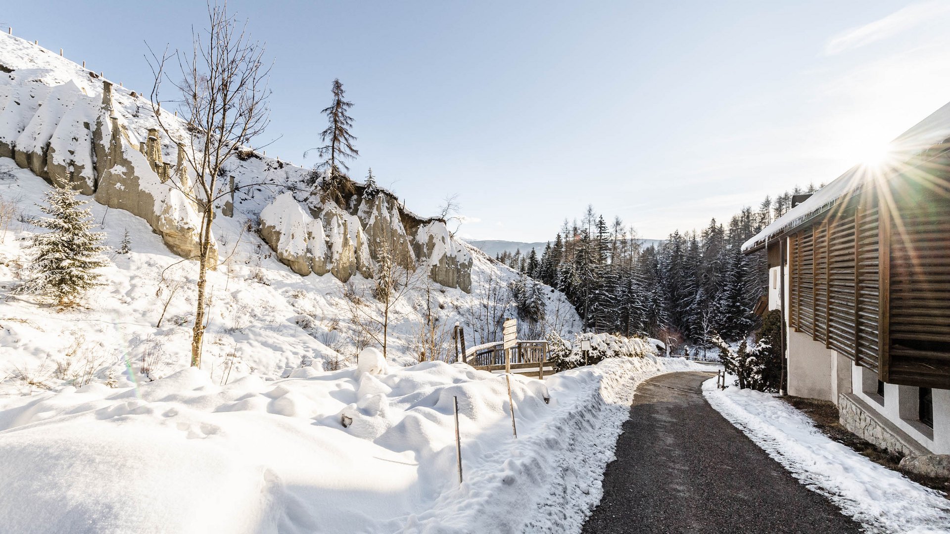 Terento in Val Pusteria Sentiero innevato accanto a casa di legno in foresta invernale soleggiata