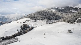 Terento in Val Pusteria Montagne innevate con bosco e piccole case sotto il cielo nuvoloso
