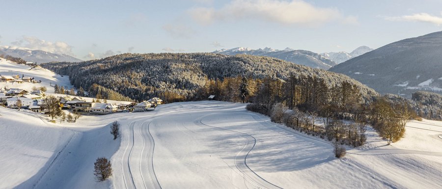 Benvenuti nell’Area Vacanze Sci e Malghe Rio Pusteria! Paesaggio innevato con montagne e bosco in inverno