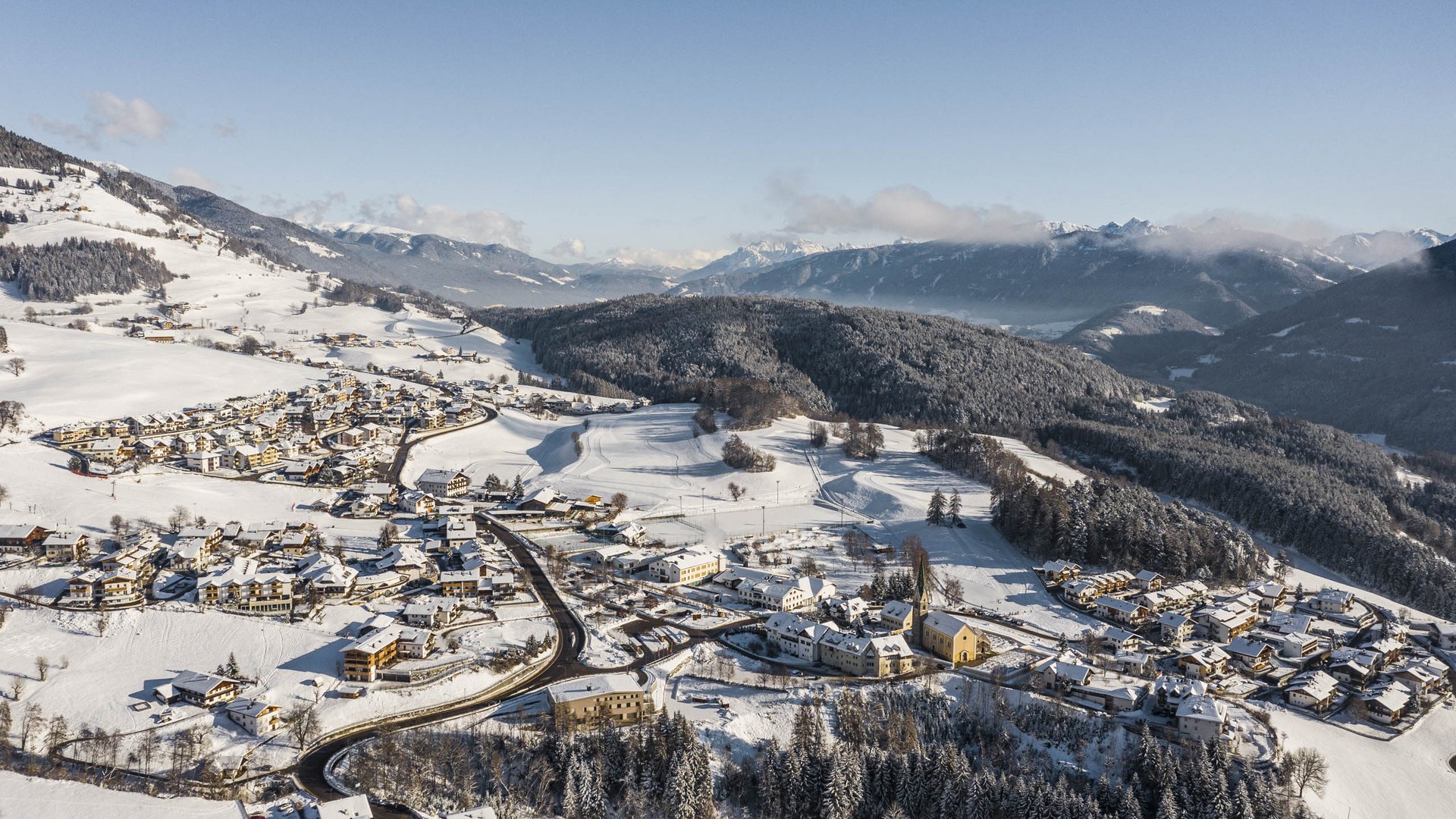 Terento in Val Pusteria Paesaggio invernale con villaggio innevato in una valle e montagne sullo sfondo