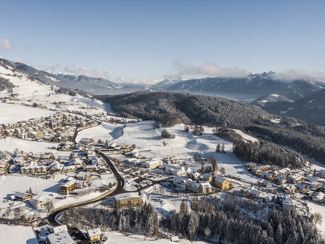 Il paradiso escursionistico di Rodengo Paesaggio invernale con villaggio innevato in una valle e montagne sullo sfondo