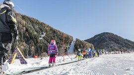 Valles & il villaggio alpino più bello dell’Alto Adige Bambini imparano a sciare su un tapis roulant in una stazione sciistica montana