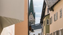 Alla scoperta di Rio di Pusteria Campanile con orologio visto attraverso un vicolo stretto tra le case